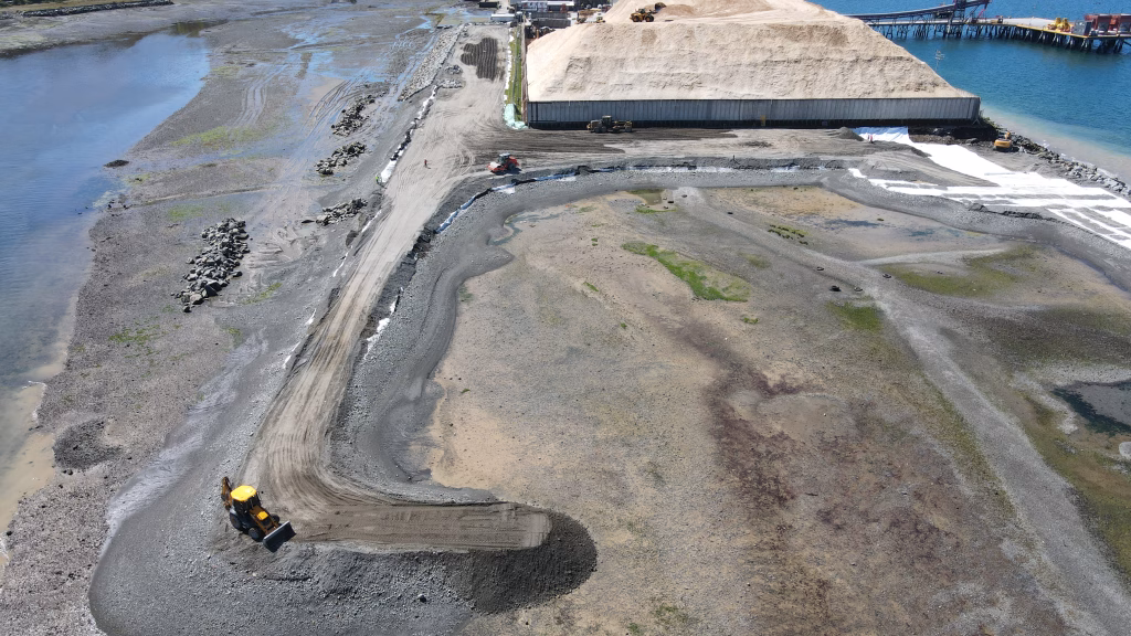 Vista aérea del sitio de construcción durante la ampliación del Puerto Punta Caullahuapi, mostrando la disposición del terreno, maquinaria y el avance de las obras.